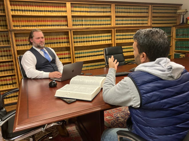 Local lawyer and veteran Bryan Boender and his friend Yasin, an Afghanistan refugee whose family settled in Eugene, discuss his new life at Boender's office. Yasin and his family have lived in Eugene for about a month after narrowly escaping Afghanistan.