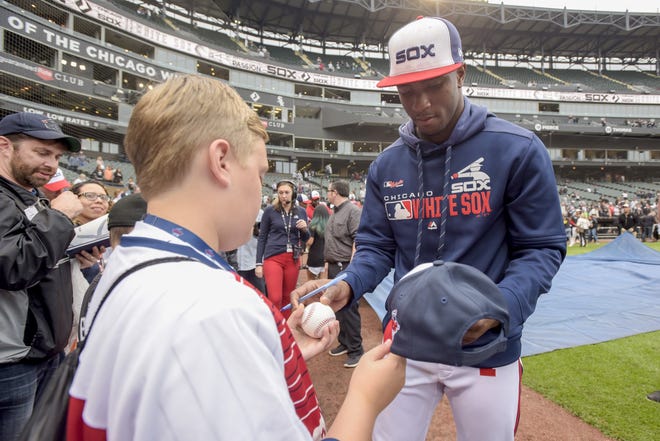The Chicago White Sox’s Tim Anderson, right, gives autographs to young fans after a win over the Detroit Tigers, Sunday. Anderson is a Tuscaloosa native who went to Hillcrest High School.  [Associated Press]