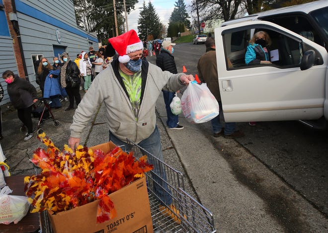 Volunteer Robert Minnitti carries a bag of Thanksgiving meal items to a car as he and fellow volunteers provide Thanksgiving food bags to those in need at St. Vincent de Paul in Bremerton on Nov. 19. St. Vincent de Paul is one of nine Kitsap-area food banks that are the beneficiaries of the money raised by the Kitsap Sun's Bellringer campaign every holiday season.