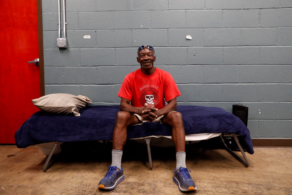 Paul Davis sits down with a smile on the cot that he slept in for a month after being picked up and given a job and housing at Manna Cafe Ministries in Clarksville, Tenn., on Thursday, Oct. 14, 2021. 
