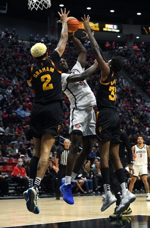 18 November 2021; San Diego, California, AS; Pemain depan San Diego State Aztecs Nathan Mensah (31) menembak bola saat dipertahankan oleh pemain depan Arizona State Sun Devils Jalen Graham (2) dan Alonzo Gaffney (32) selama babak pertama di Viejas Arena.