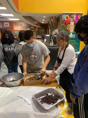 Children at the Cheyenne River Sioux Preserve in South Dakota learn how to make wasna, an indigenous food from ground buffalo meat.