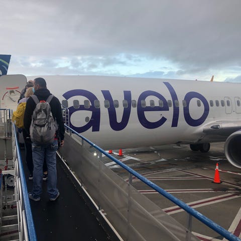 Passengers board an Avelo Airlines flight at Holly