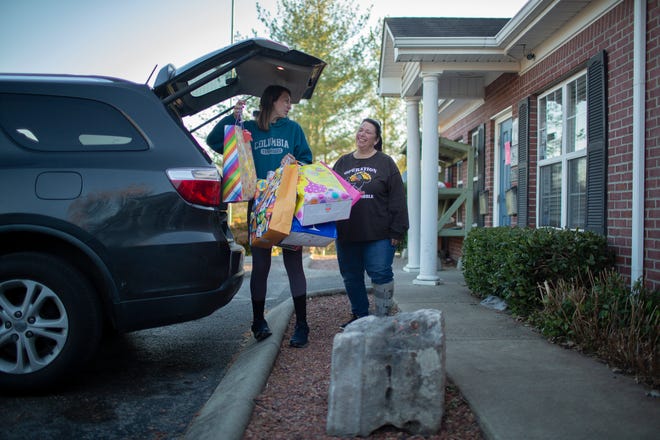Mary Prinzo and her mother Teresa Prinzo unload donated gifts for children from struggling households at  The Family Center, a nonprofit organization that offers assistance to families in need, in Columbia, Tenn., on Friday, Nov. 20, 2021.