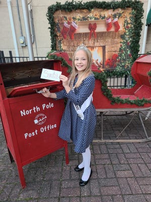 Atkinson’s 2021 Little Miss Flame, Kynlee Adam, 9, daughter of Sarah Combs, mails her letter to Santa at the North Pole Post Office located by the Atkinson Village Office, 107 West Main St. in Atkinson. The “mail box” is part of this year’s Atkinson Downtown Christmas Gathering on Friday, Dec. 3.