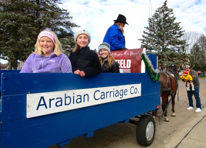 Grandparents, parents and children waited in line for a horse and wagon ride on Saturday, Nov. 20, in downtown Geneseo. The event, sponsored by Springfield Armory, was a special feature of Geneseo’s Christmas Open House which is sponsored by the Geneseo Chamber of Commerce. In the carriage are, from left, Brooklyn Frances, Tori Finegan and Izzy Ong. The Arabian Carriage, pulled by two Arabian horses, is driven by owner Tony Troyer of Mendota-Earlville.