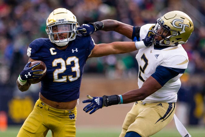 Notre Dame’s Kyren Williams (23) and Georgia Tech's Tariq Carpenter (2) exchange uncalled face masks during the Notre Dame vs. Georgia Tech NCAA football game Saturday, Nov. 20, 2021 at Notre Dame Stadium in South Bend. 