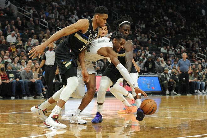 Thunder guard Shai Gilgeous-Alexander battles for the ball with Bucks forward Giannis Antetokounmpo (left) and guard Jrue Holiday at Fiserv Forum.