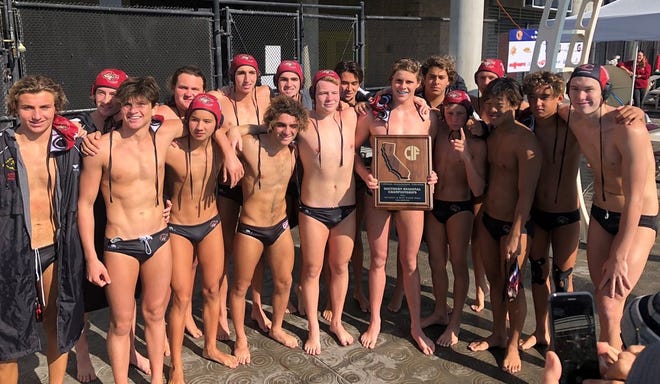 The Oaks Christian boys water polo team poses with the championship plaque after defeating Redlands East Valley 8-7 at home Saturday to win the CIF-State SoCal Regional Division II title.