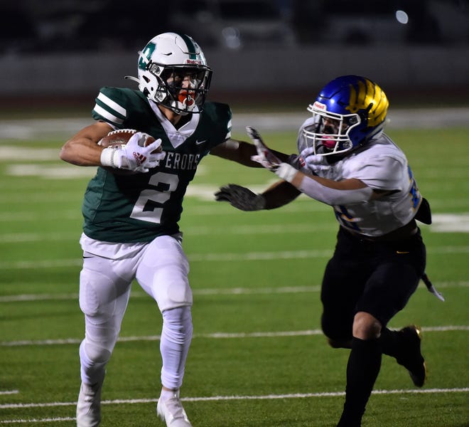 Dinuba's Mikey Olvera runs the ball against Bakersfield Christian in a Central Section DIII semifinal high school football playoff game at Claud Hebert Field in Dinuba on Friday, November 19, 2021.