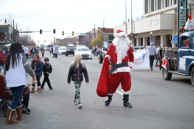 Santa Claus holds up a fist-full of candy to hand out to attendees of Hutchinson's annual downtown Christmas Parade on Saturday, Nov. 20, 2021, in Hutchinson.