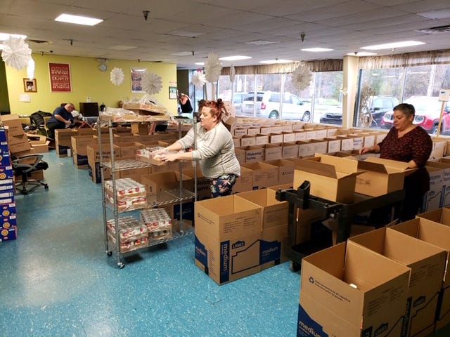 Volunteers pack boxes with Thanksgiving food Saturday for the New Leaf Project.