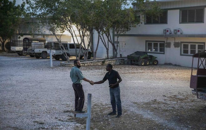 One of the managers of the Christian Aid Ministries headquarters, left, shakes hands with a worker at the center in Titanyen, north of Port-au-Prince, Haiti, Sunday, Nov. 21, 2021. Two of 17 abducted members of a missionary group have been freed in Haiti and are safe, "in good spirits and being cared for," their Ohio-based church organization, Christian Aid Ministries, announced Sunday, Nov. 21.