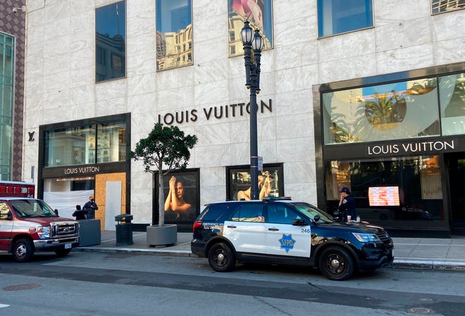 Police officers and emergency crews park outside the Louis Vuitton store in San Francisco's Union Square on Sunday, Nov. 21, 2021, after looters ransacked businesses late Saturday night. (Danielle Echeverria/San Francisco Chronicle via AP)
