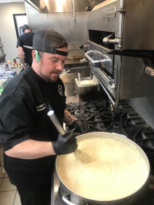 Evan Garr stirs a large pot of grits at 133 West in Kings Mountain.