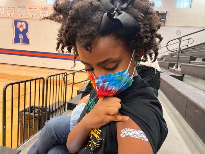 Solome Walker, 9, looks down at her bandage after getting her first Pfizer COVID-19 shot at a vaccination clinic for young students at Ramsey Middle School on Saturday, Nov. 13, 2021 in Louisville, Ky.