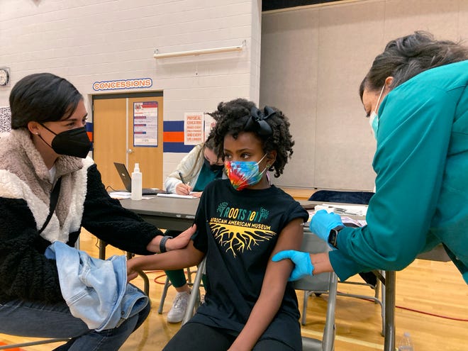 Cadell Walker comforts her daughter Solome, 9, as nurse Cindy Haskins administers a Pfizer COVID-19 shot at a vaccination clinic for young students at Ramsey Middle School on Saturday, Nov. 13, 2021 in Louisville, Ky.