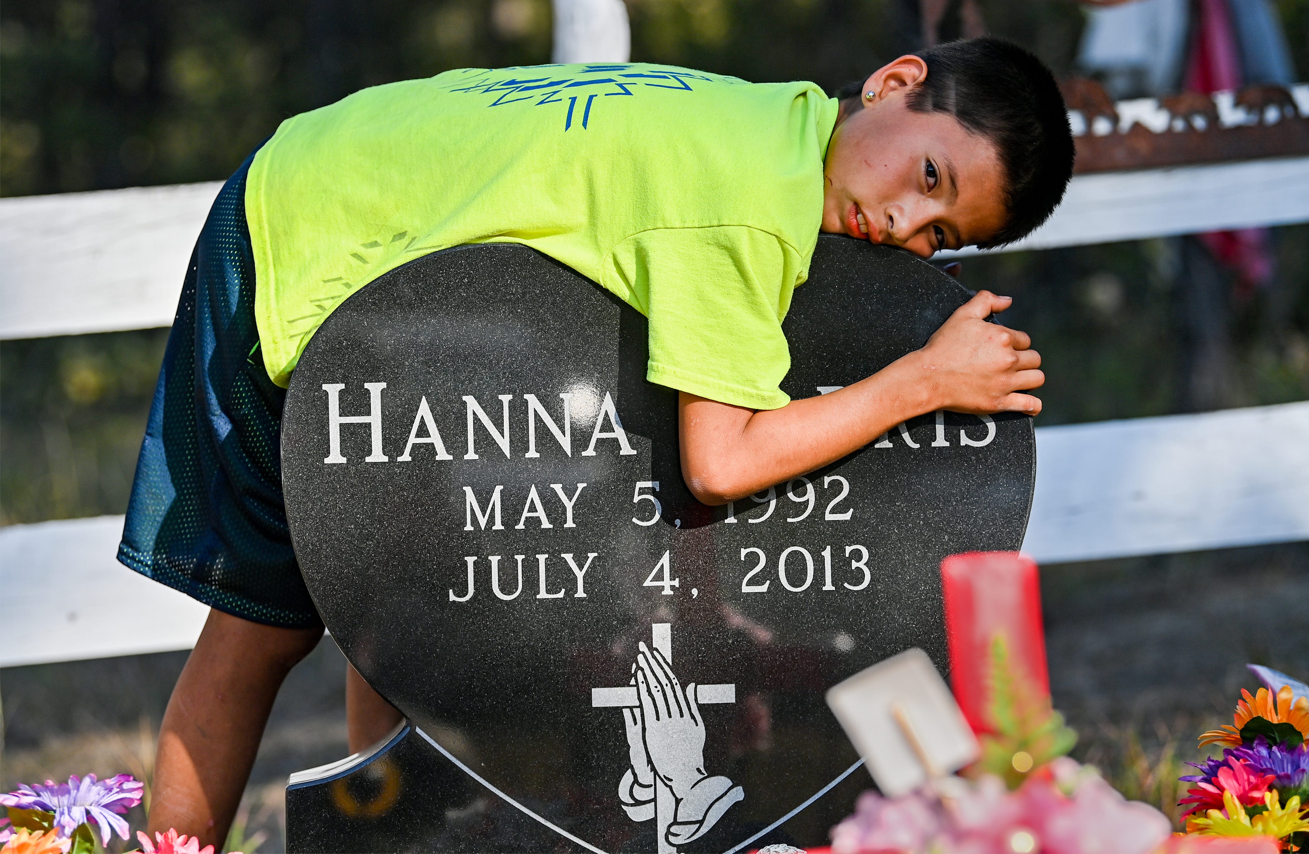 Jeremiah Harris rests on his mother's headstone at his family cemetery plot in Lame Deer.  Hanna Harris was murdered in 2013 when Jeremiah was 10 months old. Her death led to Hanna's Act, a Montana state law that allows for authorizes the Department of Justice to assist local law enforcement in missing persons cases.