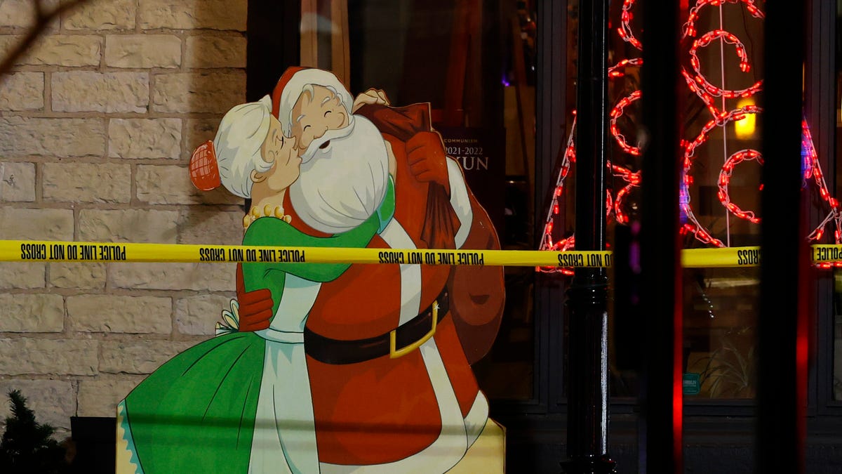 Police tape surrounds holiday decorations in downtown Waukesha, Wis., after an SUV plowed into a Christmas parade injuring dozens of people Sunday, Nov. 21, 2021.