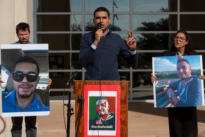 Othmane Dghoughi, flanked by photos of his brother Adil Dghoughi, calls for answers in his brother's slaying. Adil Dghoughi was fatally shot in his vehicle by a Martindale homeowner in early October.