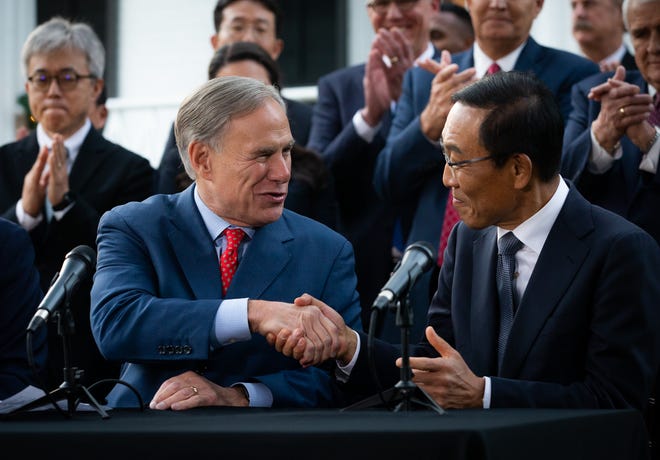 Gov. Greg Abbott and Samsung Electronics Vice Chairman Kinam Kim congratulate each other during a Tuesday news conference at the Texas governor’s mansion to announce that Samsung will build a $17 billion semiconductor plant in Taylor.