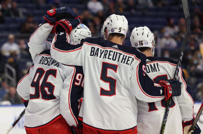 Nov 22, 2021; Buffalo, New York, USA;  Columbus Blue Jackets center Jack Roslovic (96) celebrates his goal with defenseman Gavin Bayreuther (5) and center Max Domi (16) during the first period against the Buffalo Sabres at KeyBank Center. Mandatory Credit: Timothy T. Ludwig-USA TODAY Sports