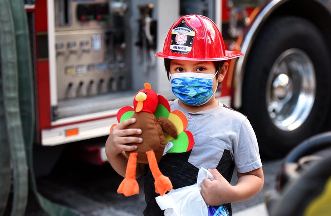 Jace Gomez, 5, holds a toy turkey as he awaits his turn to climb into a fire engine. Cancer Alliance of Help & Hope hosted a special Thanksgiving family event for over 100 of its clients dealing with cancer on Monday at the North Fire Rescue Station.