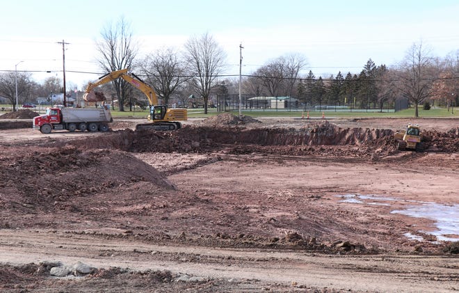 Contractors excavate a regional stormwater pond along Harrison Street in Neenah. Washington Park is visible in the background.