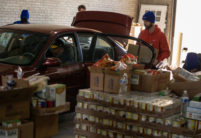 Volunteers load a car with food for a traditional Thanksgiving dinner at the Capuchin Soup Kitchen Services Center in Detroit on Tuesday, November 23, 2021.
Comerica Bank partnered with Capuchin Soup Kitchen to give 568 families from metro Detroit food to those experiencing hardship.