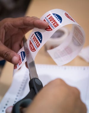 A poll worker prepares "I Voted" stickers to hand out to voters at Precinct 46 in Christ United Methodist Church in Jackson Tuesday, Nov. 23, 2021 during a special runoff election for Hinds County sheriff.