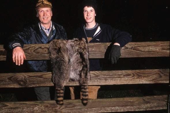 Two raccoon hunters with pelts.
