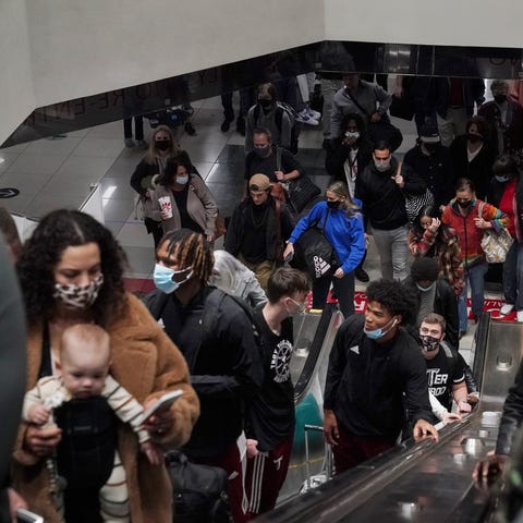 Travelers ride the escalator after their flight ar