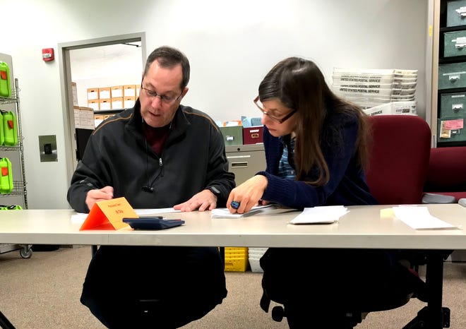 Delaware County Board of Elections employees Chip Thomson and Jenny Wiest work on a recount Nov. 23. Board of elections director Karla Herron said that in each stage of handling votes after an election, the board uses bipartisan pairs of workers to check each vote. Thomson is a Republican and Wiest is a Democrat.