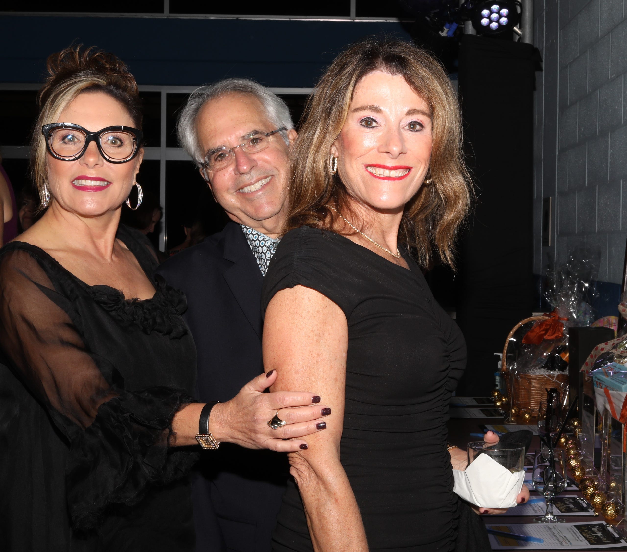 Sheree Zaslavsky, Michael Ritter and Nancy Wolk of Sarasota are perusing the silent auction table as they decide what they want to take home with them tonight.  Boys & Girls Clubs of Sarasota and DeSoto Counties held their Champions for Children Gala on November 20, 2021. Over 400 people came out to celebrate longtime supporters and donors Steven and Marjolaine Townsend who also have a scholarship fund in their name that has benefitted thirty-two college students since its inception in 2018. JANET COMBS/HERALD-TRIBUNE