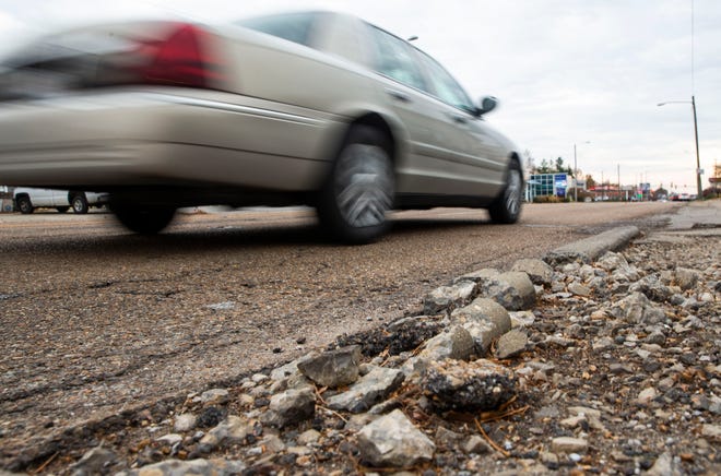 Cars travel past the crumbled curbside of Macarthur Boulevad in Springfield on Wednesday. The federal infrastructure bill that was signed last week by President Joe Biden could hasten the completion of improvements to Macarthur Boulevard and other projects around Springfield. [Justin L. Fowler/The State Journal-Register]