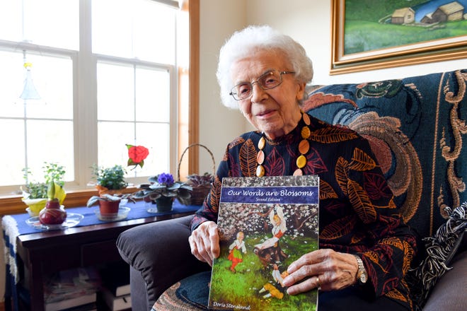 Ninety-eight-year-old Doris Stensland poses for a portrait with her new book, "Our Words Are Blossoms," on Wednesday, November 24, 2021, at her home in Sioux Falls.
