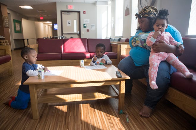 Akilah Miller, center, sits with her twin boys Zephaniah & Zayden and holds her daughter Zeniah in the common room at Gaudenzia's Safe Haven sober house Tuesday, Nov. 16, 2021.