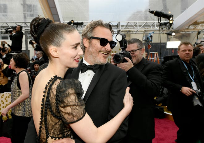 Rooney Mara, left, and Joaquin Phoenix embrace on the red carpet at the 2020 Academy Awards.