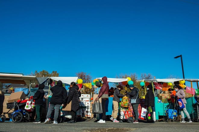 Mensen poseren vanaf een voedselbezorglijn in een supermarkt in Chelsea, Massachusetts, op 23 november 2021.