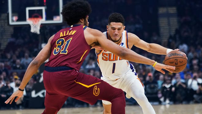 Devin Booker (1) dari Phoenix Suns mengendarai Jarrett Allen (31) dari Cleveland Cavaliers selama paruh pertama pertandingan bola basket NBA Rabu, 24 November 2021, di Cleveland.  (Foto AP/Tony Dejak)