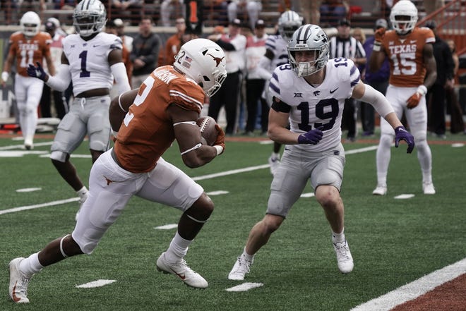 Texas running back Roschon Johnson (2) runs for a touchdown while defended Kansas State safety Ross Elder (19) tries to defend Friday at Darrell K Royal-Texas Memorial Stadium.