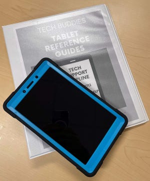 A tablet rests atop a binder of large-print, easy-to-follow instructions for those who receive a free tablet via the town of Brookline’s Tech Buddies program.