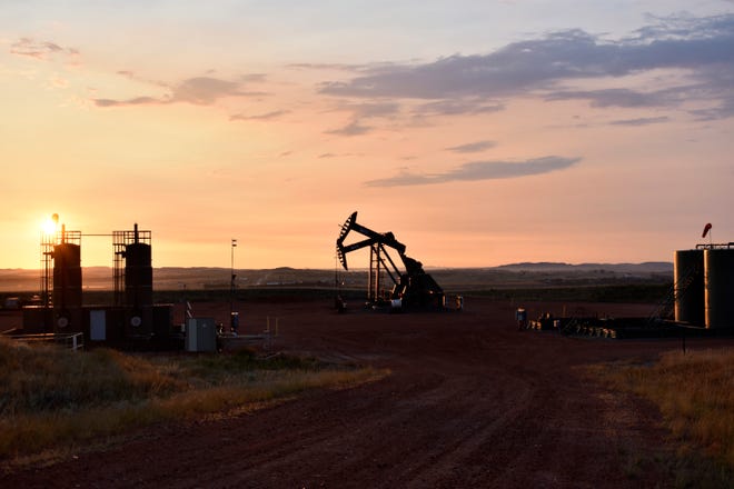Sebuah sumur minyak bekerja saat matahari terbit di Watford City, ND, bagian dari McKenzie County.