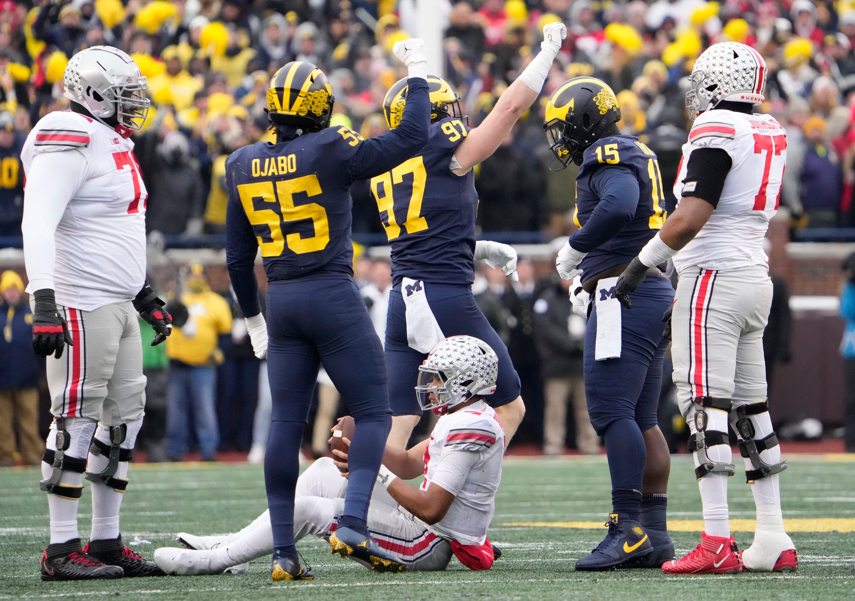 Michigan Wolverines linebacker David Ojabo (55) abnd defensive end Aidan Hutchinson (97) celebrate a sack of Ohio State Buckeyes quarterback C.J. Stroud (7) during the third quarter of the NCAA football game at Michigan Stadium in Ann Arbor on Saturday, Nov. 27, 2021.