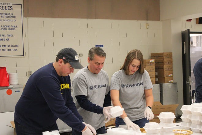 Kiwanis treasurer Joe Williams (center) Kiwanis with Nate and Brooke Gilb, get pumpkin pies ready for delivery.