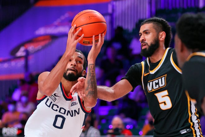 UConn guard Jalen Gaffney (0) drives the lane as VCU guard Marcus Tsohonis (5) defends during the Huskies' 70-63 overtime win at Paradise Island, Bahamas.