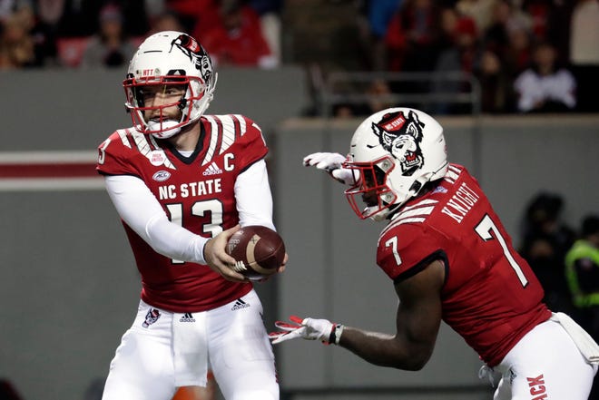 North Carolina State quarterback Devin Leary (13) hands off to running back Zonovan Knight (7) during the first half of the team's NCAA college football game against North Carolina on Friday, Nov. 26, 2021, in Raleigh, N.C. (AP Photo/Chris Seward)