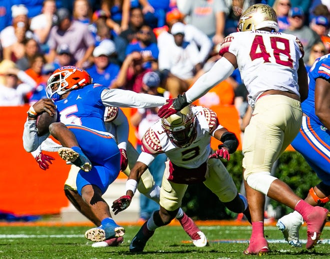Florida Gators quarterback Emory Jones (5) tries to spin out of a tackle in the first half. The Florida Gators hosted the Florida State Seminoles Saturday November 27, 2021 at Ben Hill Griffin Stadium in Gainesville, Florida. [Doug Engle/Ocala Star-Banner]2021
