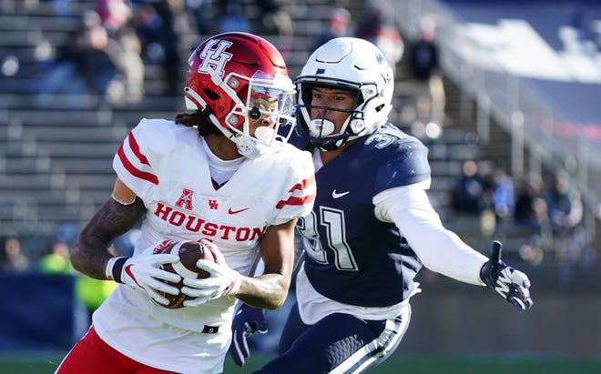 Houston Cougars wide receiver Nathaniel Dell (1) makes the catch and runs the ball against Connecticut Huskies defensive back Malik Dixon (31) in the second quarter at Rentschler Field at Pratt & Whitney Stadium.