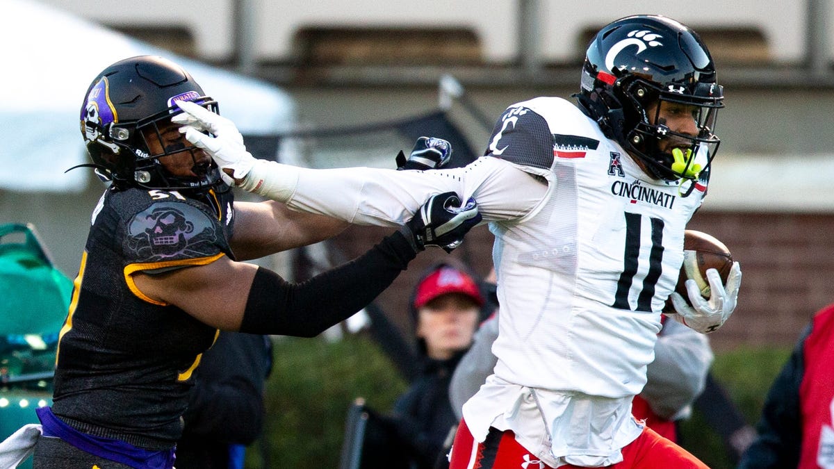 Cincinnati tight end Leonard Taylor scores a touchdown as East Carolina linebacker Aaron Ramseur attempts to stop him in the first half.